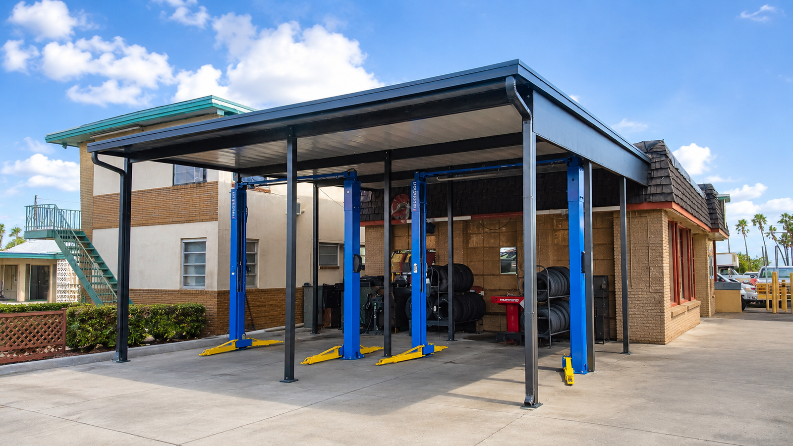 Commercial shop carport cover protecting work vehicles in Houston Texas