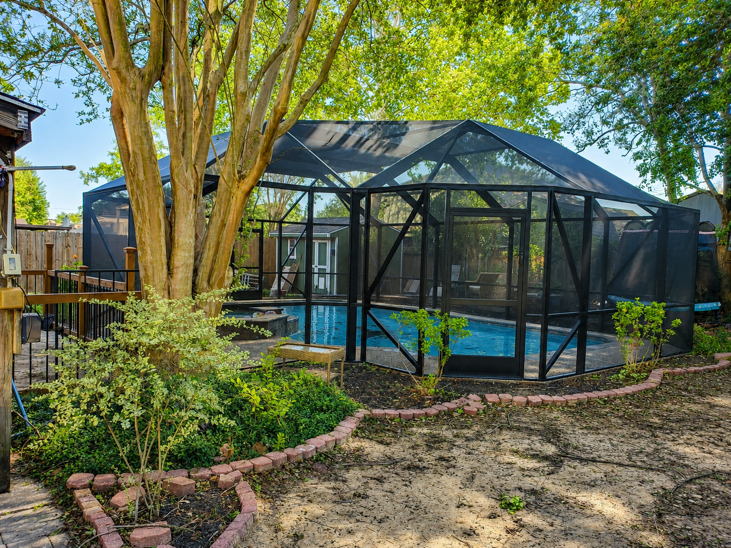 Pool enclosure connected to a patio seating area